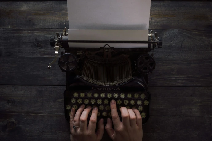 person holding white and black typewriter